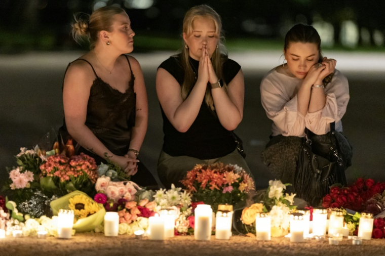 Des personnes offrent des prières lors d'une veillée nocturne pour le roi Harald V de Norvège sur la place du Palais à Oslo, tôt le 28 août 2026. ( AFP / Odd ANDERSEN )