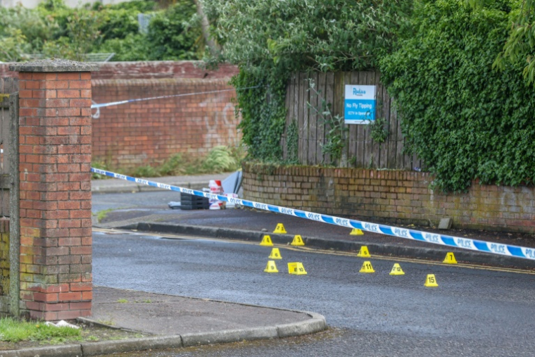 Des marquages de la police médico-légale derrière un cordon de sécurité sur les lieux d'une agression au couteau avenue Kinnaird, dans le nord de Belfast, en Irlande du Nord, le 9 juin 2026 ( AFP / Paul Faith )
