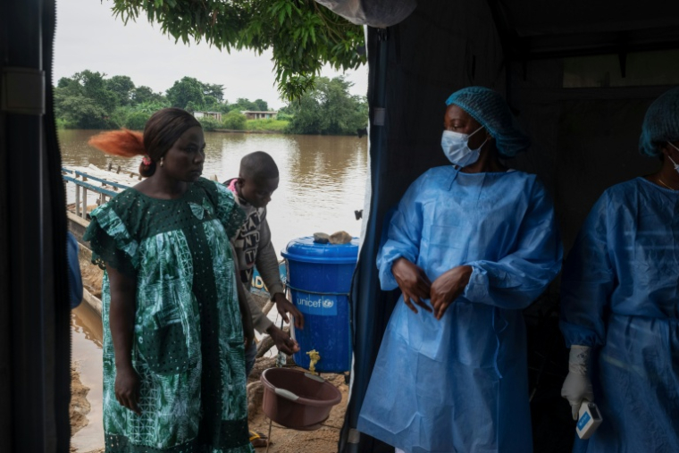 Un voyageur se lave les mains avant qu'on lui prenne sa température, à son arrivée au débarcadère de M’Poko Bac, dans le district de Bimbo, au sud-ouest de Bangui, le 28 octobre 2026 en Centrafrique ( AFP / - )