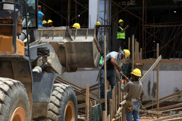 Des ouvriers sur le chantier de l'hôpital central Al-Wahda, construit à Derna dans le cadre des travaux de réhabilitation,  le 17 mai 2026 ( AFP / Abdullah DOMA )