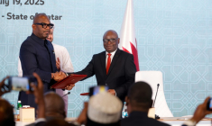 Le chef de la délégation congolaise Sumbu Sita Mambu (G) serre la main du secrétaire exécutif du groupe armé M23,  Benjamin Mbonimpa (D), après avoir signé une déclaration de principe comprenant un accord de cessez-le-feu, le 19 juillet 2025 à Doha ( AFP / Karim JAAFAR )