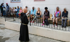 Le frère franciscain Luis Pernas s'adresse à des habitants qui patientent devant l'église catholique Santa Cruz de Jérusalem avant une distribution gratuite de médicaments, à La Havane, le 14 avril 2026 ( AFP / YAMIL LAGE )
