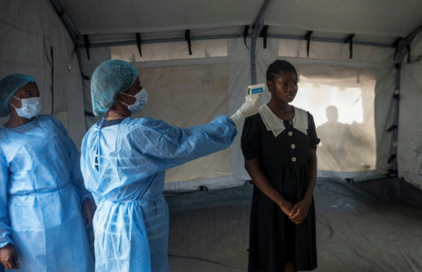 Une agente de santé prend la température d’une voyageuse à son arrivée au débarcadère de M’Poko Bac, dans le district de Bimbo, au sud-ouest de Bangui, le 28 octobre 2026 en Centrafrique ( AFP / - )