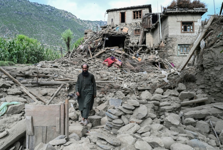 Un homme afghan passe devant une maison endommagée à la suite de tremblements de terre dans le village de Mazar Dara, situé dans le district de Nurgal, dans la province de Kunar, à l'est de l'Afghanistan, le 1er septembre 2025 après un séisme de magnitude 6,0 ( AFP / Wakil Kohsar )