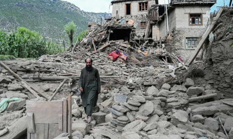 Un homme afghan passe devant une maison endommagée à la suite de tremblements de terre dans le village de Mazar Dara, situé dans le district de Nurgal, dans la province de Kunar, à l'est de l'Afghanistan, le 1er septembre 2025 après un séisme de magnitude 6,0 ( AFP / Wakil Kohsar )