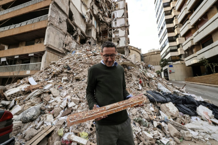 Wael Sabbagh, qui a perdu sa mère et son frère dans une frappe israélienne contre leur immeuble, se tient devant le bâtiment, dans le quartier de Tallet el-Khayat, à Beyrouth, le 18 mai 2026 ( AFP / Anwar AMRO )