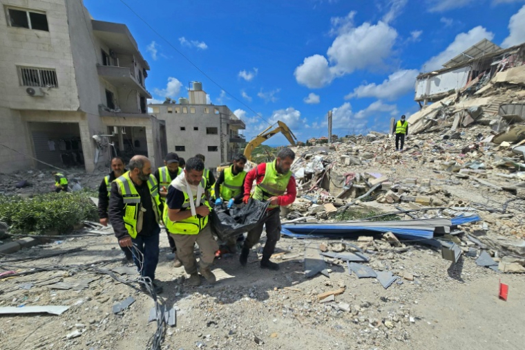 Des secouristes tirent un corps des décombres, après une frappe israélienne sur le village libanais de Qana (sud), le 12 avril 2026 ( AFP / Kawnat HAJU )