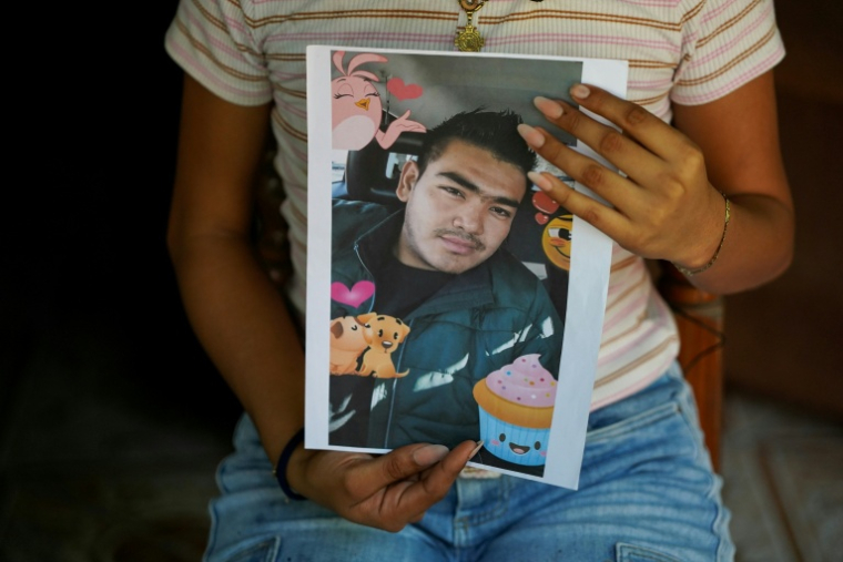 Jade, 16 ans, tient dans ses mains le portrait de son père Jose Roger Urquilla, le 3 décembre 2025 à El Rosario, au Salvador. ( AFP / STRINGER )