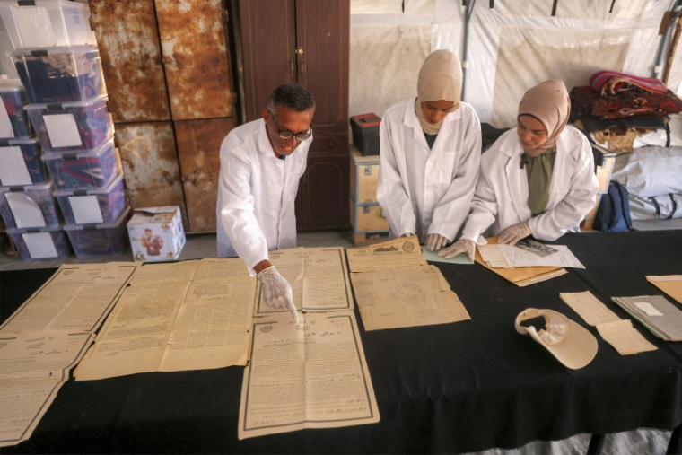 Des membres de l'association Mayasem pour la culture et les arts, examinent des documents anciens, le 11 juillet 2026 à Khan Younès, dans le sud de la bande de Gaza ( AFP / Bashar Taleb )