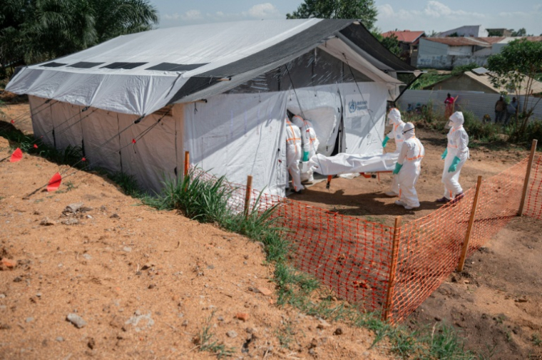 Des soignants portent le corps d'une personne décédée du virus Ebola dans la morgue du Centre médical évangélique de Nyankunde (CME), le 13 juin 2026 à Bunia, dans la province de l'Ituri, en RDC ( AFP / Jospin Mwisha )