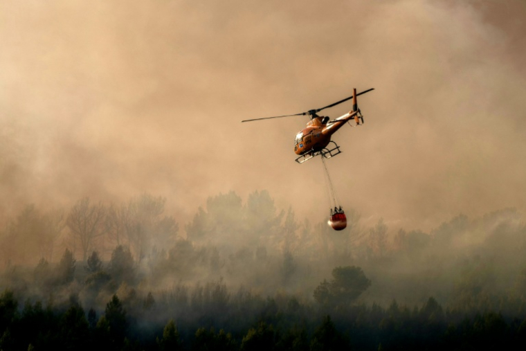 Un hélicoptère des pompiers lutte contre les flammes à Pouzols-Minervois, dans l'Aude, le 2 juillet 2026 ( AFP / Idriss Bigou-Gilles )