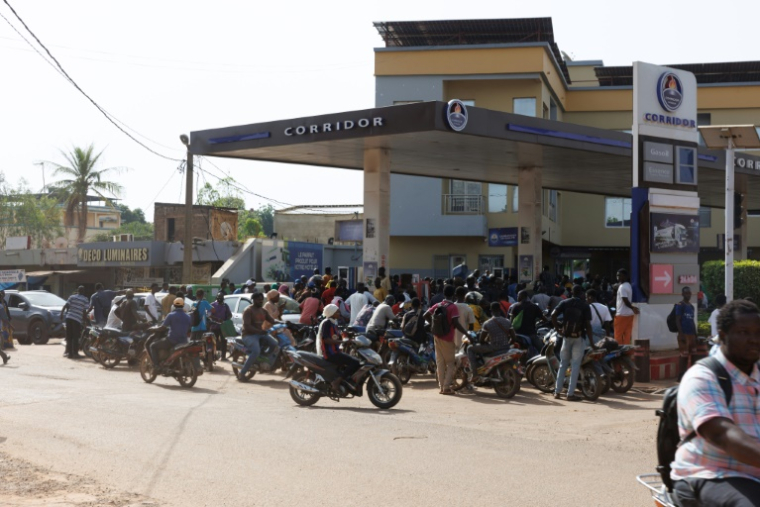 Des véhicules et motocyclistes font la queue pour tenter d'obtenir de l'essence à une station dans la capitale malienne Bamako le 7 octobre 2025. Un blocus jihadiste en cours depuis un mois sur le carburant importé des pays voisins provoque des pénuries et commence à perturber fortement ce pays sahélien enclavé ( AFP / - )