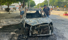 Des personnes inspectent une voiture incendiée à la suite d'une opération de l'armée colombienne contre le groupe armé ACSN, à Santa Marta, en Colombie, le 22 septembre 2026 ( AFP / Idinael FERNANDEZ )