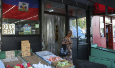 Le drapeau haïtien et un poster promouvant la Coupe du Monde sur la vitrine d'une boutique dans le quartier de Little Haiti à Brooklyn, New York, le 19 mai 2026 ( AFP / ANGELA WEISS )