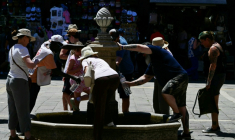 Des touristes se rafraîchissent à une fontaine publique à Venise, lors d'un épisode de canicule en Europe, le 27 juin 2026 ( AFP / Stefano RELLANDINI )