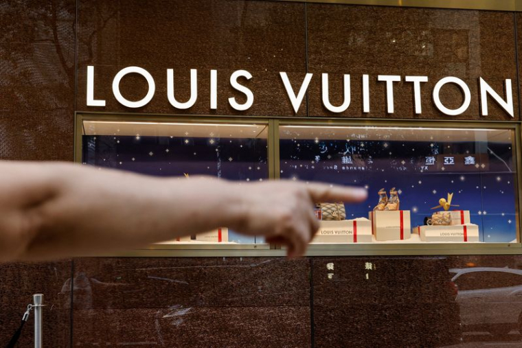 Un touriste devant un magasin Louis Vuitton à Tsim Sha Tsui, un quartier commerçant animé, à Hong Kong.