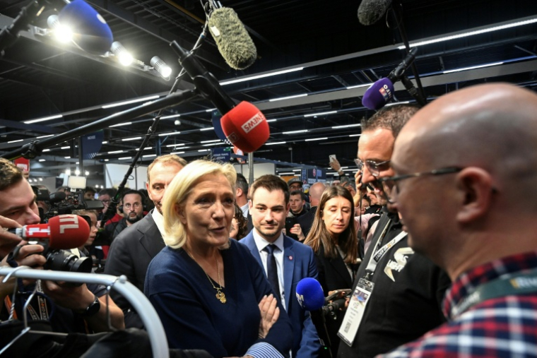 La cheffe de file du Rassemblement nationale, Marine Le Pen, parle avec des exposants lors du congrès des sapeurs-pompiers au Mans, le 10 octobre 2025 dans la Sarthe ( AFP / JEAN-FRANCOIS MONIER )