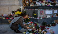 Une femme dépose des fleurs en hommage aux victimes du 13 novembre 2015, Place de la République à Paris, le 11 novembre 2025 ( AFP / Dimitar DILKOFF )
