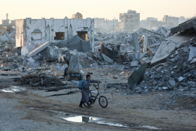 Un garçon palestinien pousse son vélo dans les ruines de Gaza-Ville le 22 octobre 2025. ( AFP / Omar AL-QATTAA )