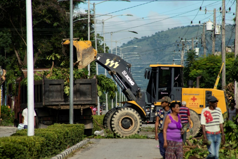 Des équipes dégagent les branches d’arbres élaguées avant l’arrivée de Melissa à Santiago de Cuba, le 25 octobre 2025. ( AFP / STRINGER )
