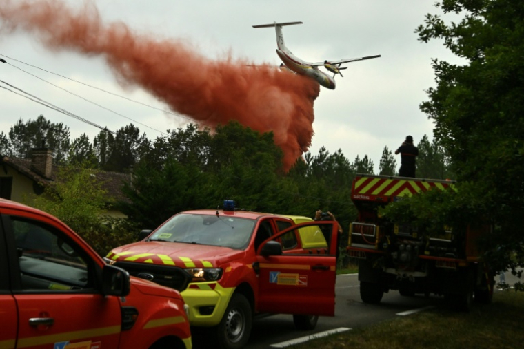 Un avion Dash 8 Q400 MR largue du retardant pour éviter des sautes de feu dans la forêt des Landes, près de Luglon, le 15 août 2026 ( AFP / Gaizka IROZ )