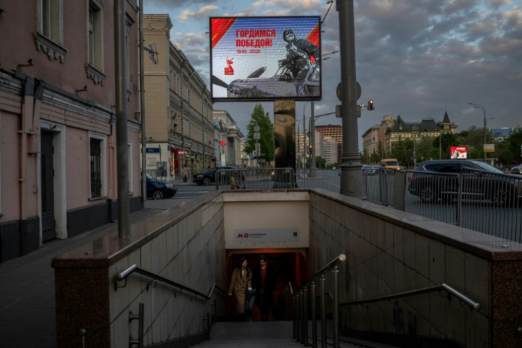 Un écran au-dessus de l'entrée d'un passage souterrain affiche une image commémorative de la victoire du 9 mai 1945, le 7 mai 2025 à Moscou ( AFP / Angelos TZORTZINIS )