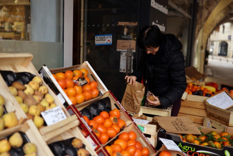 Une femme achète des fruits et légumes dans un magasin à Agen