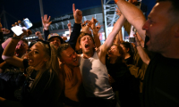 Les fans du groupe de rock britannique Oasis se réjouissent à l'extérieur du Principality Stadium à Cardiff le 4 juillet 2025 ( AFP / Oli SCARFF )