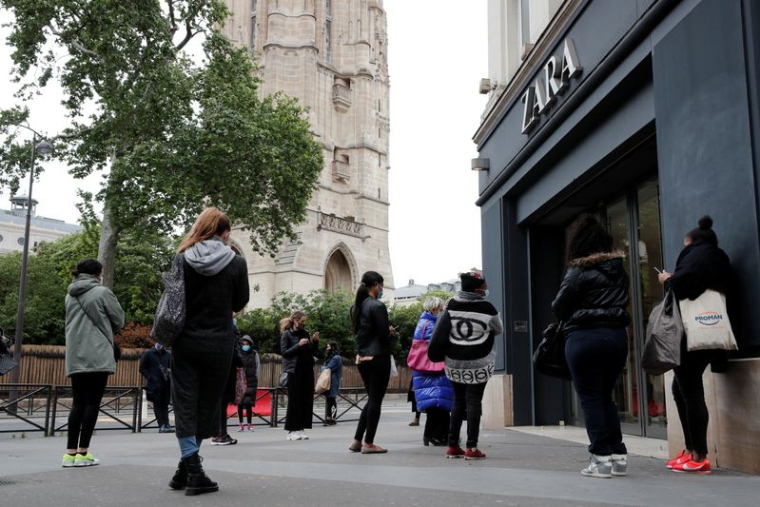 Des clients attendent devant un magasin à Paris