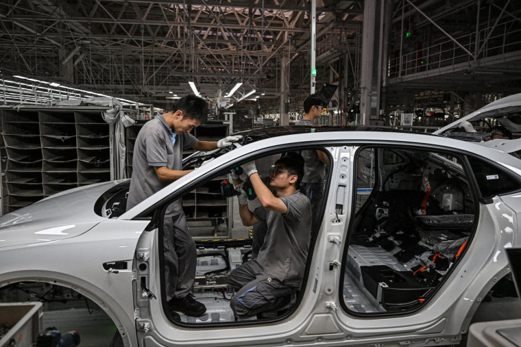 Des employés travaillent sur une chaîne de production de véhicules électriques dans une usine du constructeur chinois Nio à Hefei, dans la province chinoise de l'Anhui, le 24 septembre 2025. ( AFP / JADE GAO )