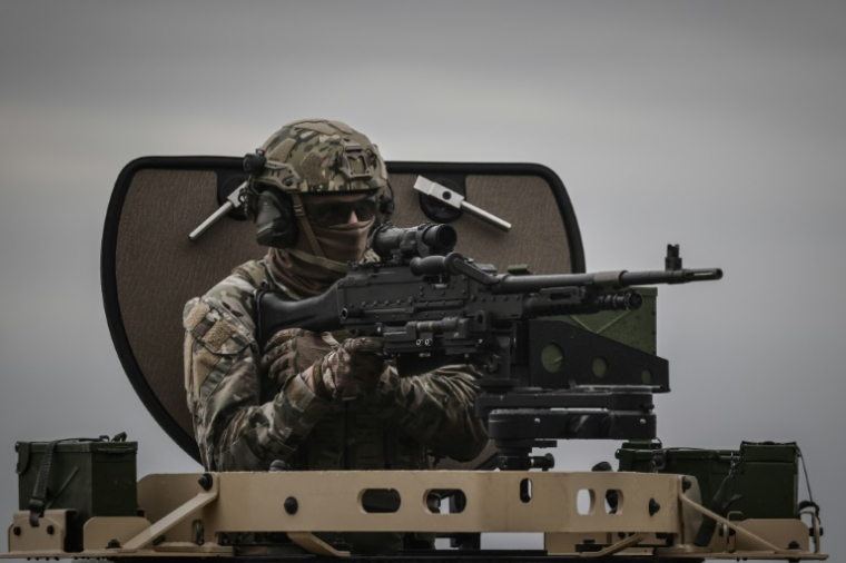 Un membre des forces spéciales de l'armée française manie une mitrailleuse sur un véhicule blindé lors d'une démonstration tactique dans le cadre de la 7e édition du salon Sofins, à Martignas-sur-Jalle, le 3 avril 2025 en Gironde ( AFP / Philippe LOPEZ )