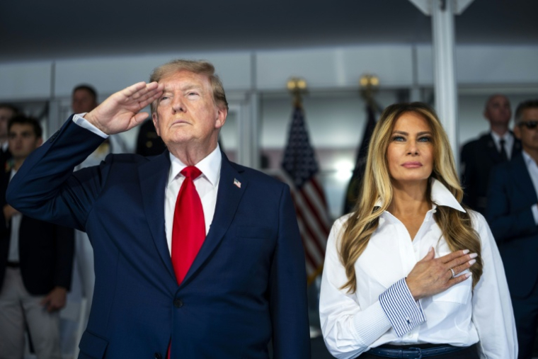 Le président américain Donald Trump et la première dame Melania Trump se tiennent debout pendant l'hymne national au début de la course d'Indycar organisée à Washington pour célébrer le 250e anniversaire des Etats-Unis, le 23 août 2026 ( GETTY IMAGES NORTH AMERICA / POOL )