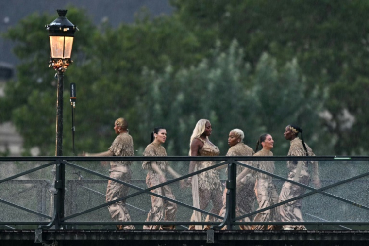 Aya Nakamura (C) et des danseurs sur le Pont des arts pour la cérémonie d'ouverture des Jeux olympiques à Paris le 26 juillet 2024 ( AFP / Gabriel BOUYS )