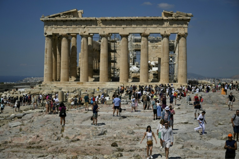 Des touristes le visitent le Parthenon, à Athènes, le 14 juin 2023 ( AFP / Louisa GOULIAMAKI )