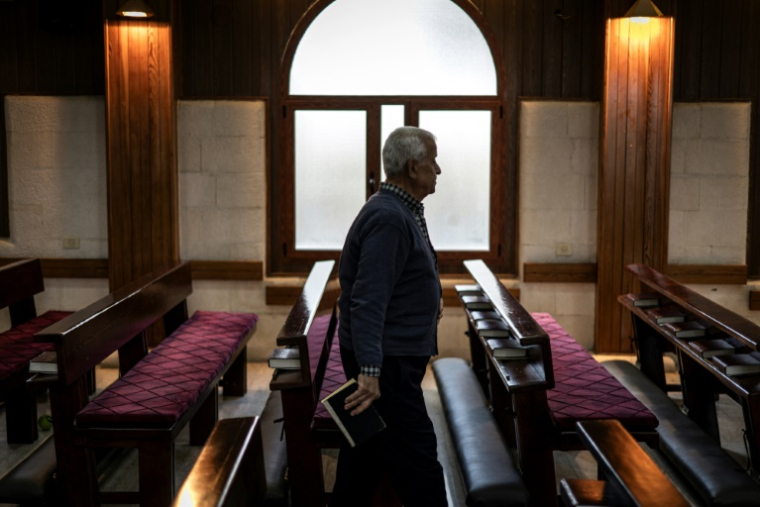 Un fidèle chrétien dans l'église anglicane de Zababde, en Cisjordanie occupée, le 10 avril 2025 ( AFP / John WESSELS )