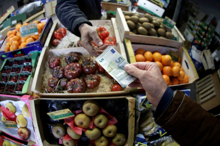 Un client règle ses achats sur un marché à Nice