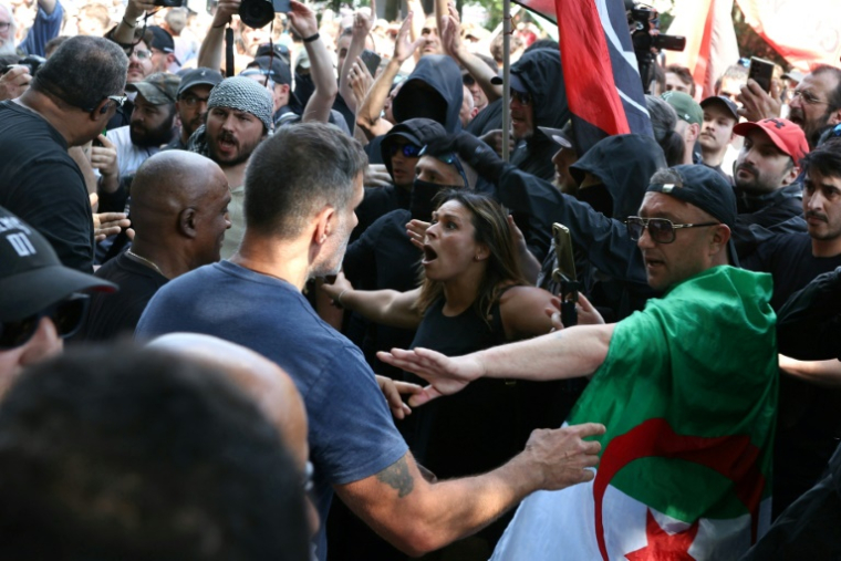 Un membre du personnel de sécurité du Parti socialiste (PS) (g) se heurte aux manifestants et aux militants antifascistes de gauche (antifa) lors d'un rassemblement marquant la Journée internationale des travailleurs, le 1er mai 2025 à Paris ( AFP / Alain JOCARD )