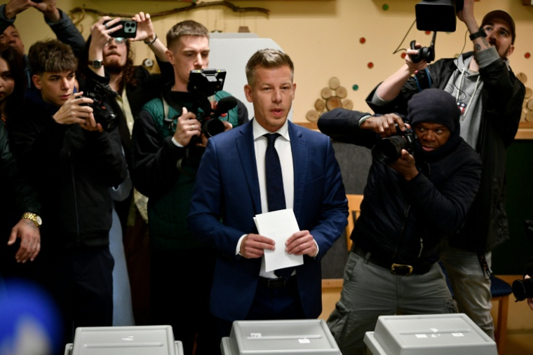 Peter Magyar (c), chef du parti conservateur pro-européen Tisza s'apprête à voter à Budapest, lors des législatives en Hongrie, le 12 avril 2026 ( AFP / Ferenc ISZA )