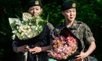 Deux des membres du boys band de K-pop BTS, Jungkook (g) et Jimin à leur arrivée à Yeoncheon, le 11 juin 2025 en Corée du Sud, après leur libération de 18 mois de service militaire ( AFP / ANTHONY WALLACE )