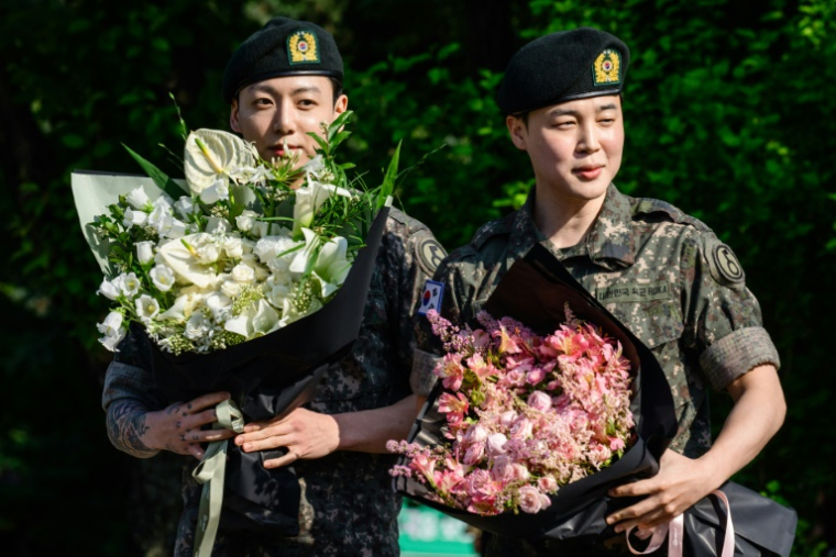 Deux des membres du boys band de K-pop BTS, Jungkook (g) et Jimin à leur arrivée à Yeoncheon, le 11 juin 2025 en Corée du Sud, après leur libération de 18 mois de service militaire ( AFP / ANTHONY WALLACE )