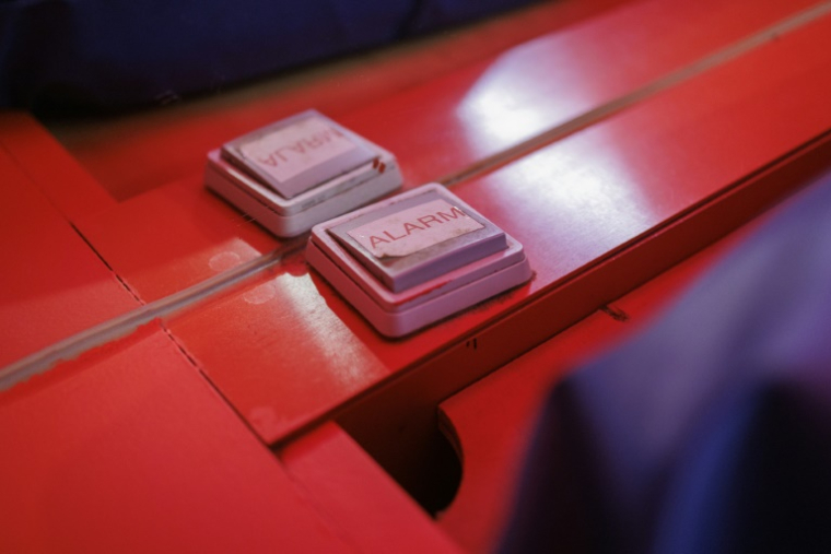 Un bouton d'alarme directement relié au poste de police voisin posé à côté du lit dans une chambre de la "Villa Tinto", lieu légal pour le travail du sexe à Anvers, le 1er avril 2025 en Belgique ( AFP / Simon WOHLFAHRT )