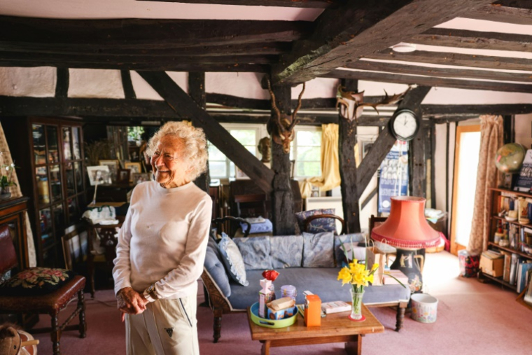 Dorothea Barron, 100 ans, vétérane britannique de la Seconde Guerre mondiale, dans le salon de son cottage, près de Harlow, le 31 mars 2025 au nord de Londres ( AFP / Adrian DENNIS )