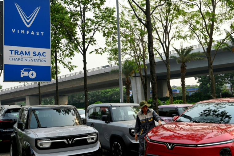 Un employé inspecte une voiture électrique dans une concession Vinfast à Hanoï, le 11 avril 2026 au Vietnam ( AFP / Nhac NGUYEN )
