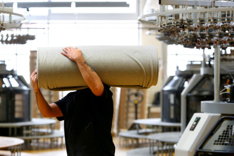 Un employé déplace des draperies dans l'usine de l'entreprise textile "TRIGEMA" à Burladingen