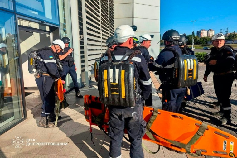 Photo diffusée par le Service d'État ukrainien pour les situations d'urgence, prise le 21 août 2026, montrant des secouristes sur le site d'un centre commercial endommagé par une frappe russe à Kryvyï Rih, en Urkaine ( Service d'État ukrainien pour les situations d'urgence / Handout )