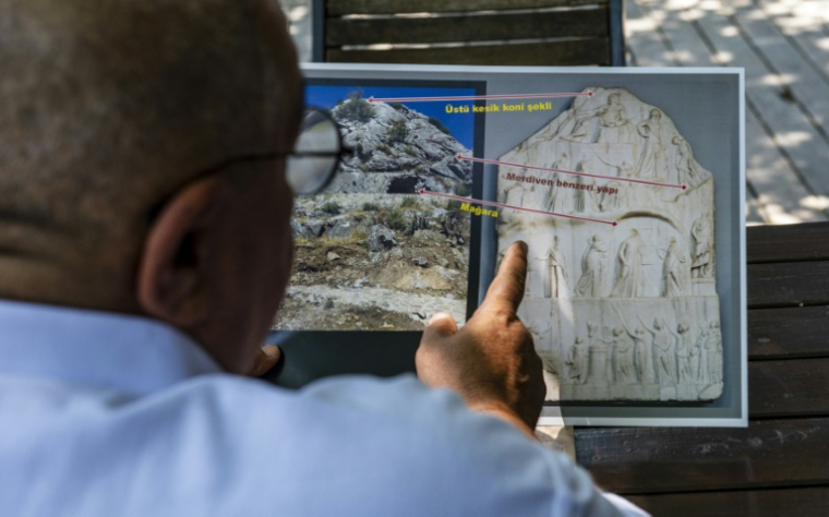L'historien Altan Altin montre sur un écran une stèle conservée au British Museum qui, selon lui, représente une cérémonie de déification d'Homère, le 7 août 2026 à Izmir, en Turquie ( AFP / Ahmet Ayberk Cimen )