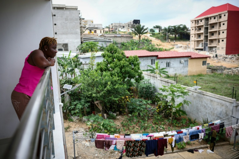 Adèle Koue Sungbeu, une Ivoirienne de 45 ans qui a subi une chirurgie réparatrice après avoir été excisée enfant, sur son balcon à Abidjan (Côte d'Ivoire), le 11 avril 2025 ( AFP / Anne-Christine POUJOULAT )