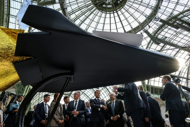 Le président Emmanuel MAcrone (C) avec le PDG de Dassault Eric Trappier (C-D) au sommet spatial à Paris, le 9 septembre 2026 ( POOL / Ludovic MARIN )