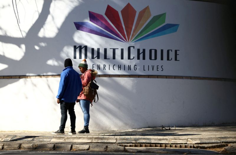 Un couple sous le logo de MultiChoice au siège de la société à Randburg