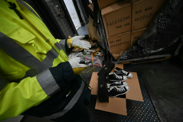 Un agent des douanes inspecte des chaussures contrefaites au Havre, en Seine-Maritime, le 3 juin 2026 ( AFP / Lou BENOIST )